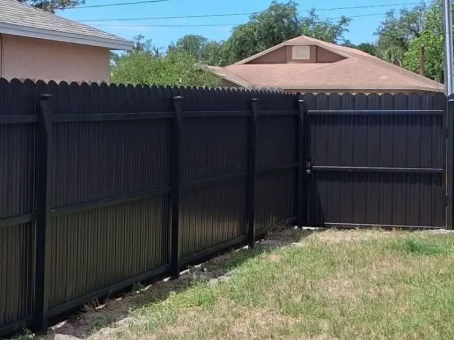 Fence company Port St. Lucie, FL — dark privacy fence with double gate along a side yard