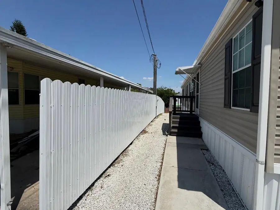 Fence company Vero Beach, FL — white vinyl fence along a side-yard walkway