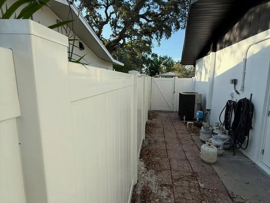 Fence company Crystal River, FL — white vinyl fence and gate along a side yard