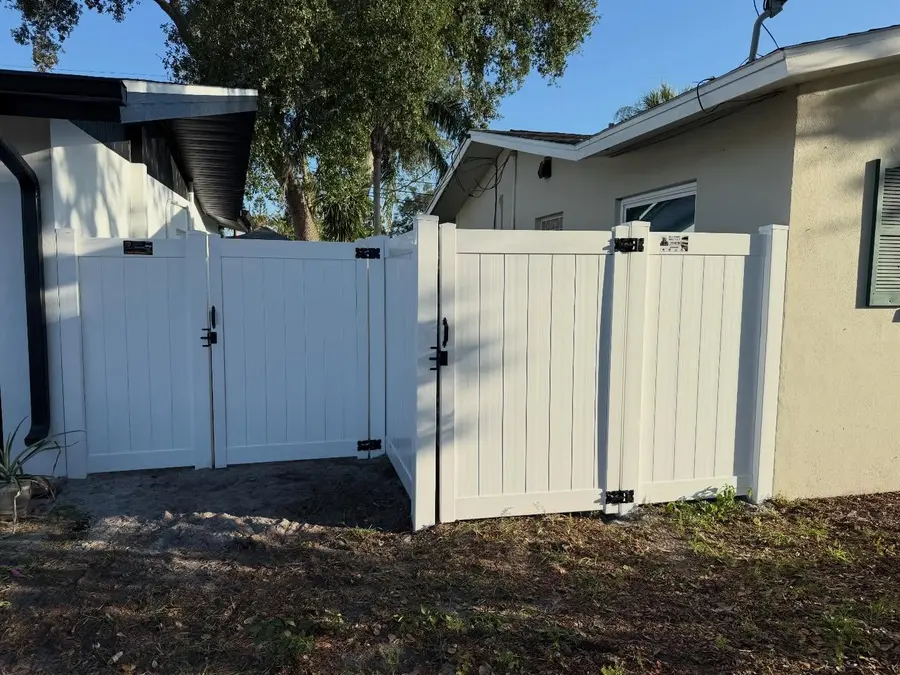 Fence company The Villages, FL — white vinyl double gate at a side entry