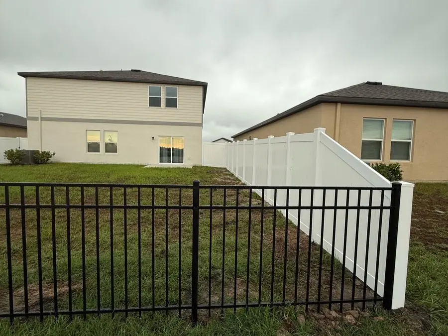 Fence company Cocoa Beach, FL — black aluminum fence and white vinyl privacy fence at a new-construction home