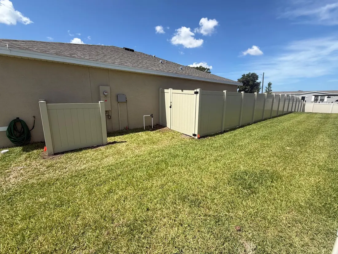 White vinyl fence along a shaded yard